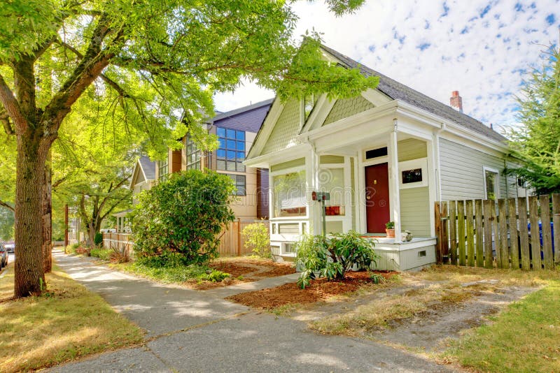 Small cute craftsman American house wth green and white and red door.