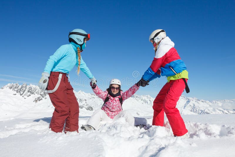 Small family on winter vacation playing in the snow on the ski slopes with colorful equipment royalty free stock photos Small family on winter vacation playing in the snow on the ski slopes with colorful equipment royalty free stock photos
