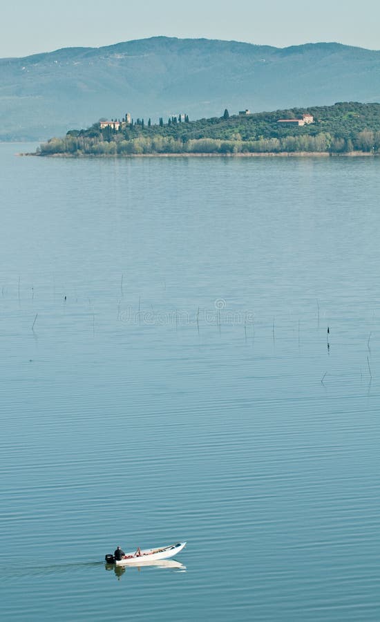 Small fishing boat crossing lake