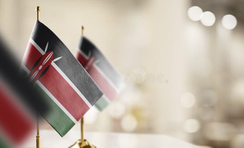 Small flags of the Kenya on an abstract blurry background vector illustration