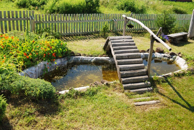 Small garden pond with wooden bridge