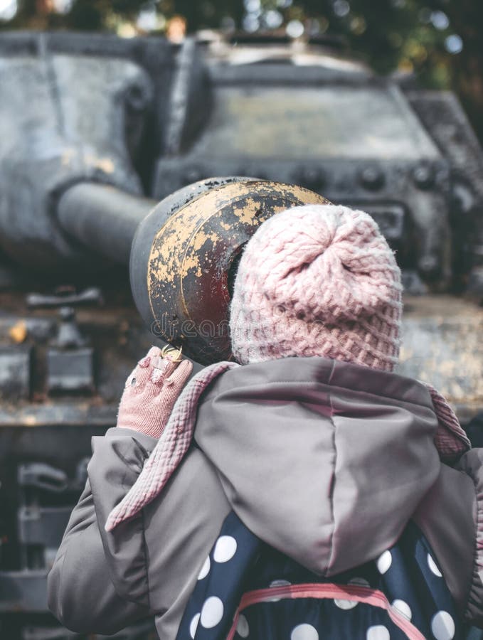 Girl looking down the barrel of tank