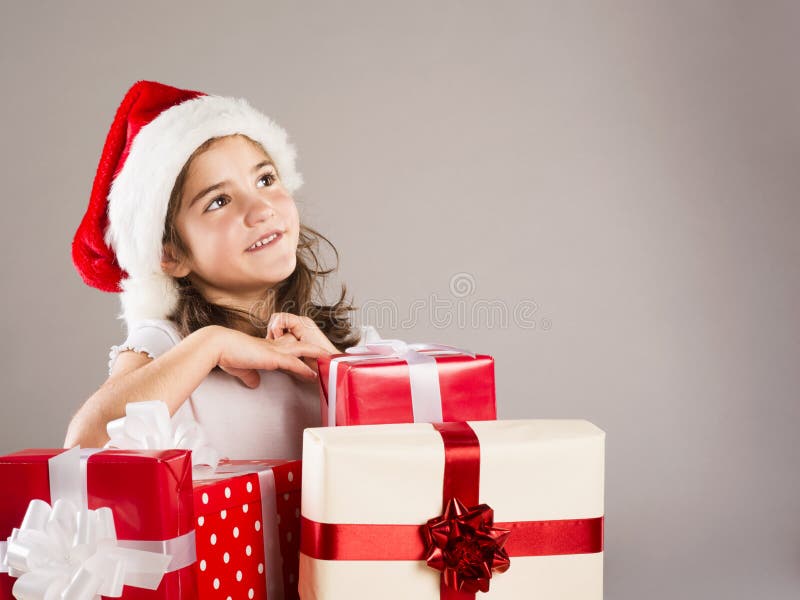 Small girl in santa hat with christmas gift stock photos Small girl in santa hat with christmas gift stock photos