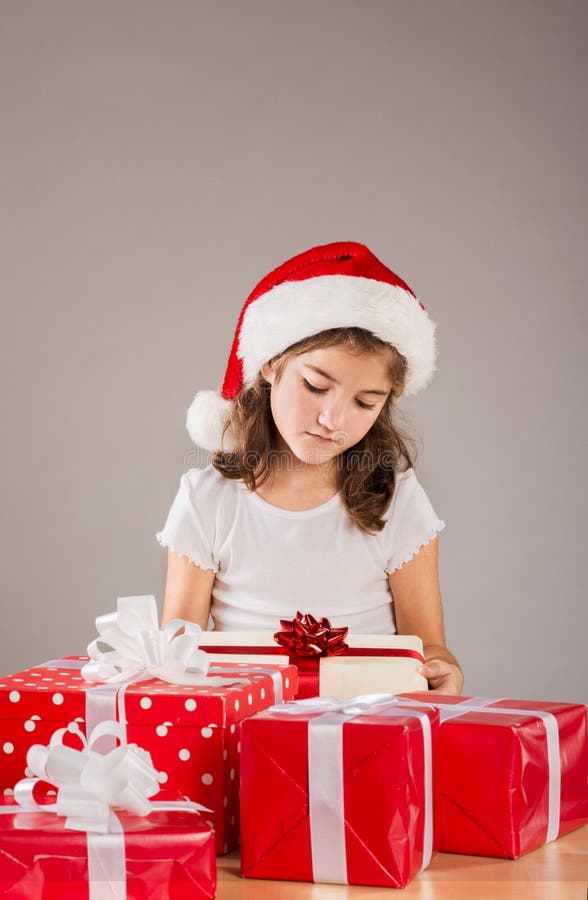 Small girl in santa hat with christmas gift stock photo Small girl in santa hat with christmas gift stock photo