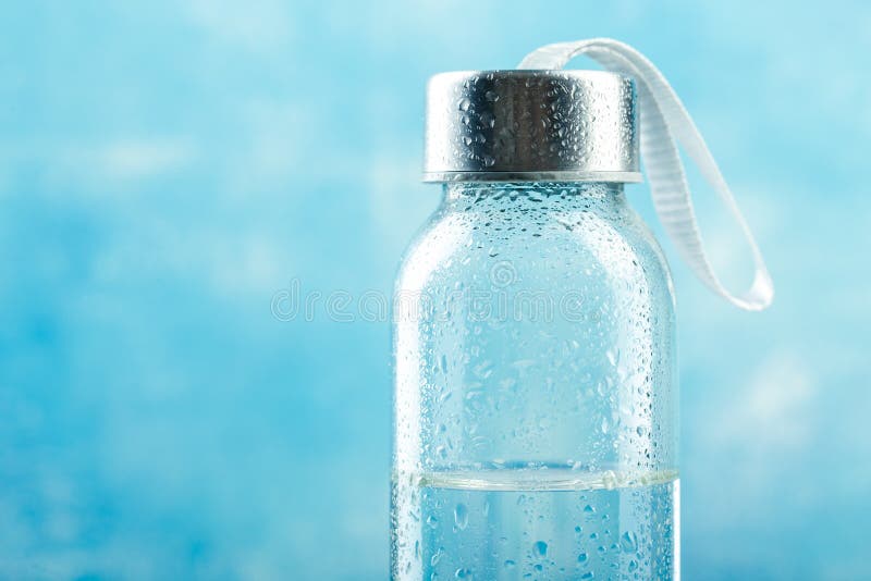 https://thumbs.dreamstime.com/b/small-glass-water-bottle-drops-blue-background-143132342.jpg