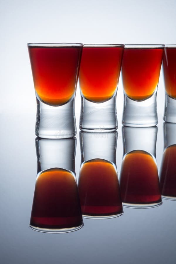 Small Glasses with a Drink Shots of Alcohol Stainding in a Table Stock