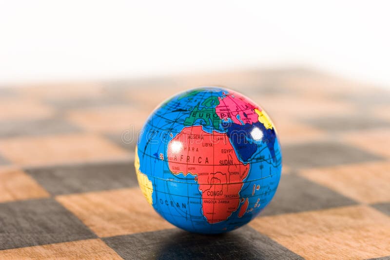 Small globe on an old chessboard