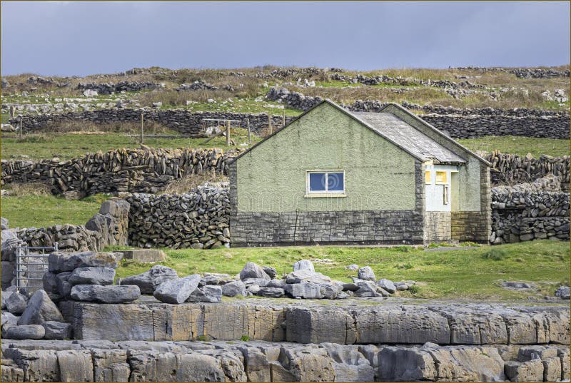 Small green painted building in a series of limestone walls royalty free stock photo