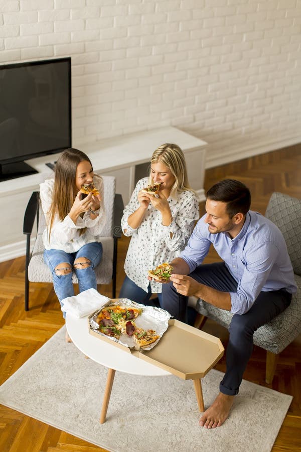 Young friends eating pizza in the room royalty free stock photos Young friends eating pizza in the room royalty free stock photos