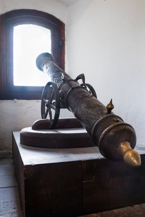 A small gun is standing in a niche by the window in the Bran Castle. Bran city in Romania