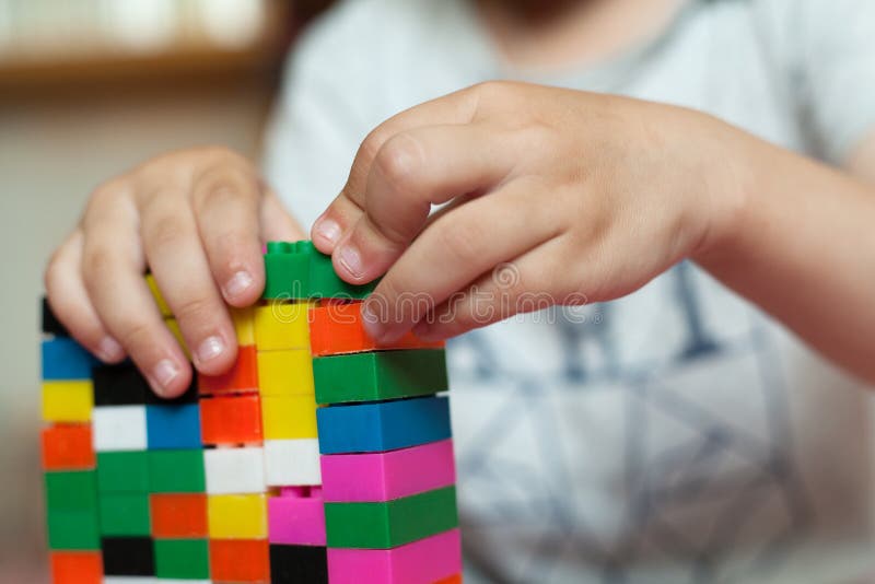 Small Hands Of The Child Collects The Bright Plastic Colored Designer