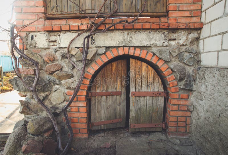 Small hobbit door in a stoned wall. Building exterior. Faded, light, sunny hipster colors.