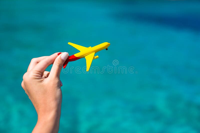 Small homemade plane in female hand on background
