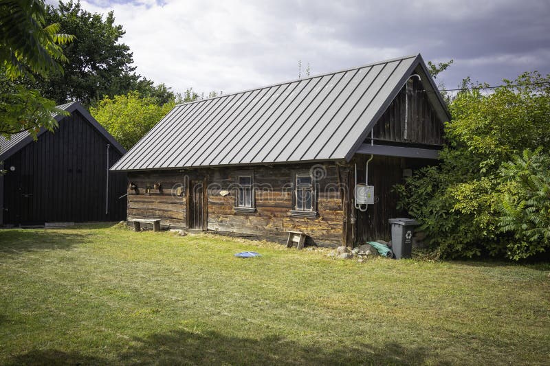 A small house with a green trash can in front of it royalty free stock image