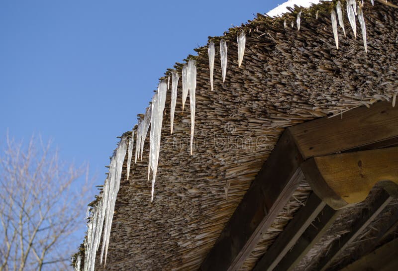 Small icicles retro straw roof background blue sky