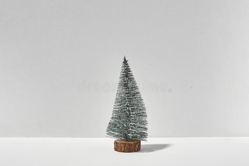 Small lonely christmas tree on white background with sunlight shadow. quarantine christmas stock images