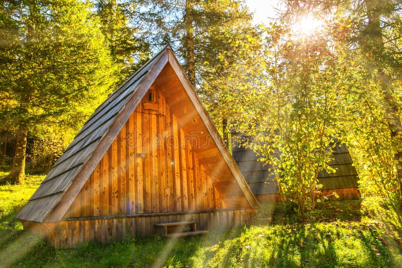 Small natural wooden house hidden far away in a deep green forest on a sunny morning day stock photography Small natural wooden house hidden far away in a deep green forest on a sunny morning day stock photography