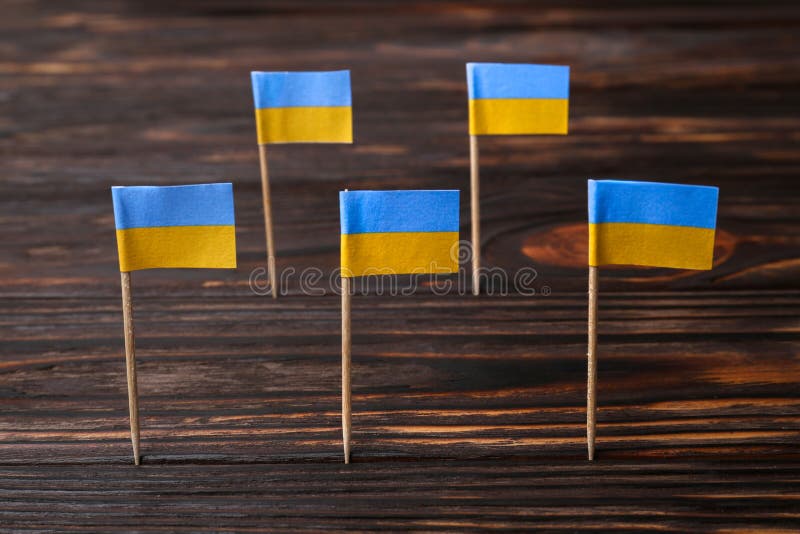 Small paper flags of Ukraine on wooden table stock photography