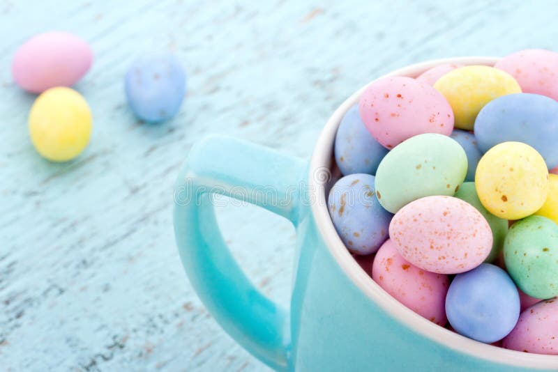 Small pastel easter eggs in a blue cup