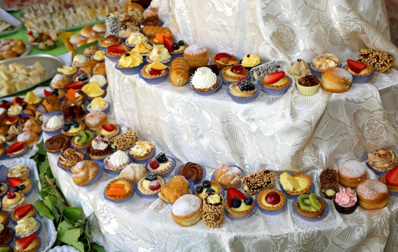 Small pastries and cream puffs stuffed with creams and fruits at a company buffet