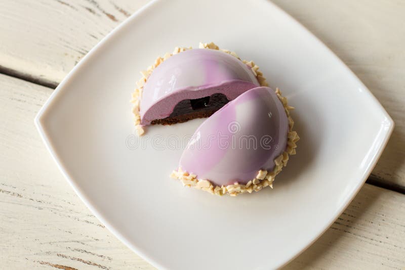 Small pink cake on plate.