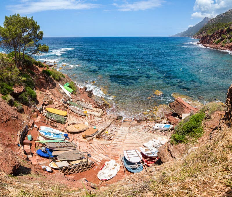 Small port with fishing boats. View over sea and mountains.