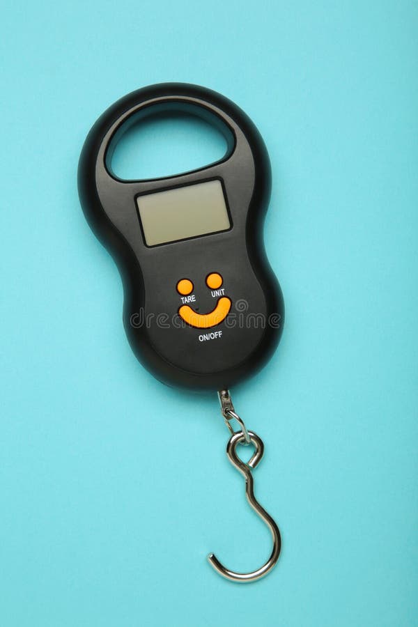 Small portable electronic scale on blue background. Vertical photo royalty free stock image