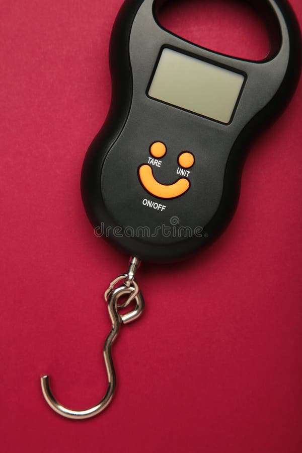 Small portable electronic scale on red background. Vertical photo stock photography