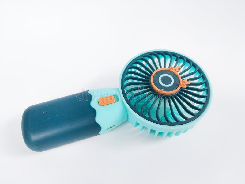 A small portable handheld fan in turquoise and dark blue color with an orange button stock photo