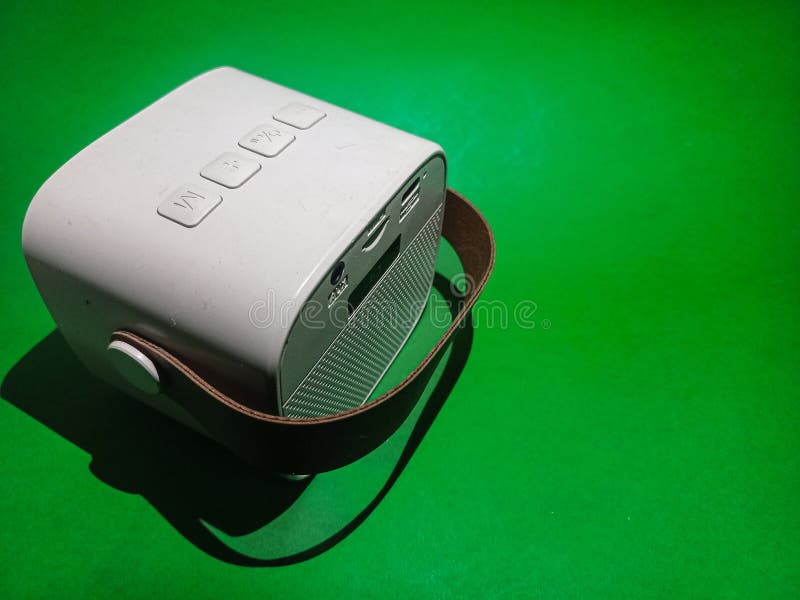 A small portable speaker sits on a bright green surface. royalty free stock photos