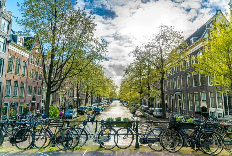 Amsterdam, The Netherlands, April 22, 2017: Small quiet canal with bikes on bridge in front in the Center of Amsterdam