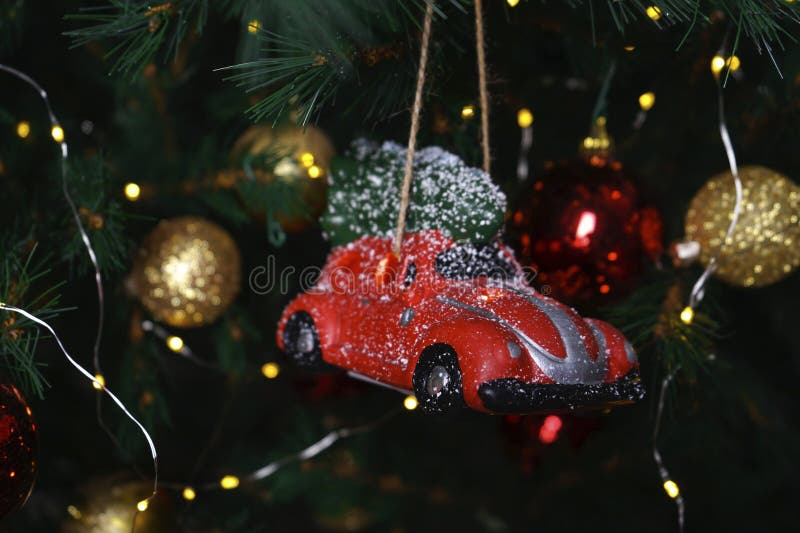 Small red car bauble and toys on a christmas tree. Christmas composition royalty free stock image Small red car bauble and toys on a christmas tree. Christmas composition royalty free stock image