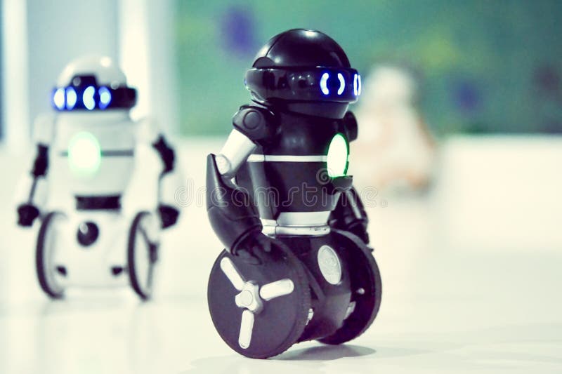 Small robots, humanoid with small wheels instead of legs and luminous eyes. royalty free stock image Small robots, humanoid with small wheels instead of legs and luminous eyes. royalty free stock image