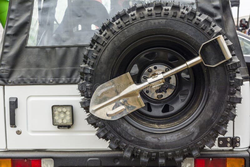 Small shovel and spare wheel in an off-road vehicle.