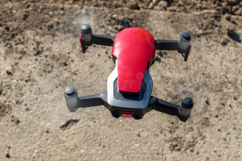 Small Sized Red Drone with High Resolution Camera Hovering in Air for Aerial Photography Stock