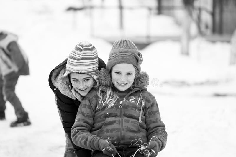 Small southern romanian village. Scenes from a moody winter with children playing with sledges and enjoying the snow