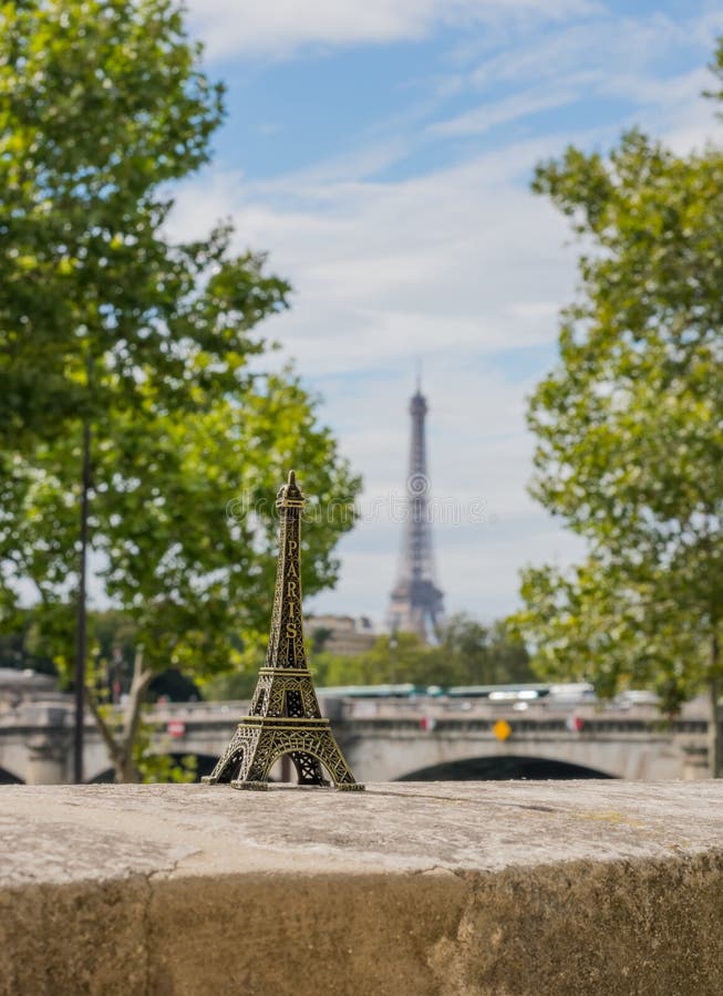 Small Eifel Tower on the Real Eiffel Tower Background Stock Photo