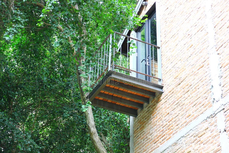 Small terrace install on brick wall near big tree stock images