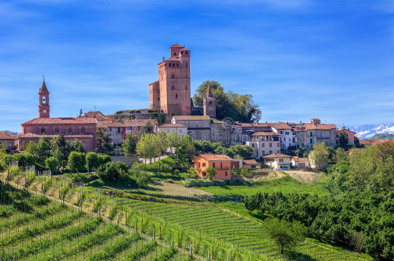 Malé mesto so stredovekým hradom a zelených viníc na zjazdové na jar v Piemonte, v Severnom Taliansku.