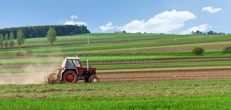 Small tractor harrow on the spring field royalty free stock images