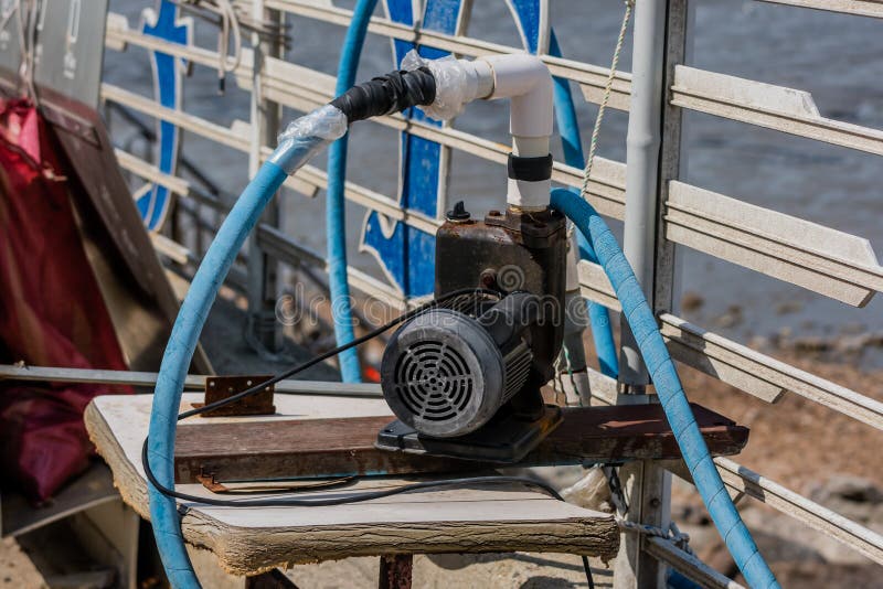 Small two stroke sump pump with attached hoses royalty free stock image