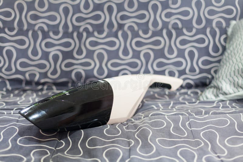 Small Vacuum Cleaner on the Couch. Stock Photo Image of chores