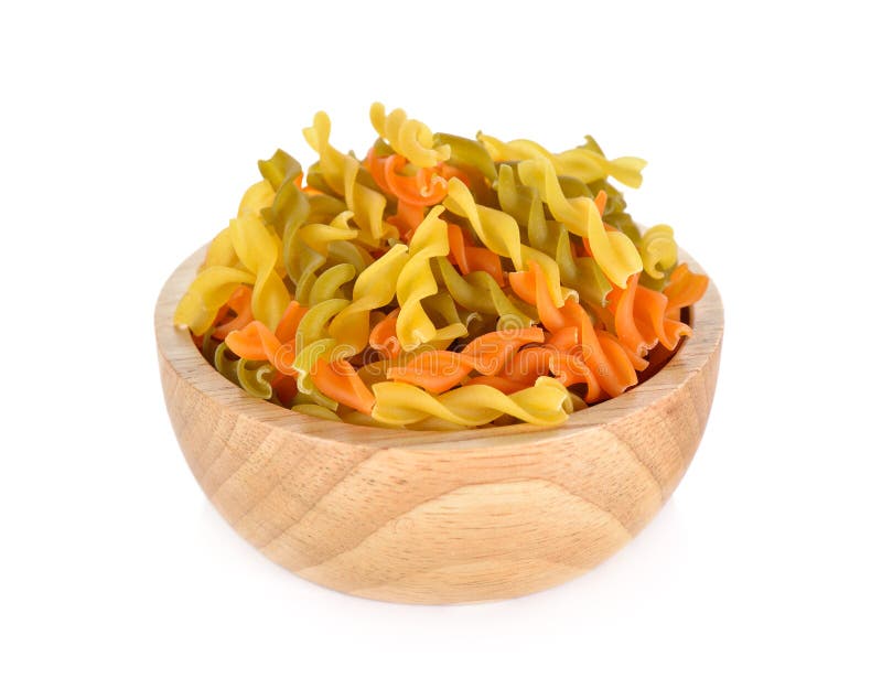 Small vegeroni Rotini spirals pasta in wooden bowl on white back stock images
