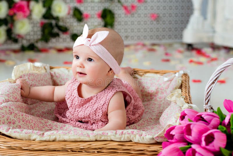 Small very cute, big-eyed little girl in a pink dress lying in a royalty free stock image Small very cute, big-eyed little girl in a pink dress lying in a royalty free stock image