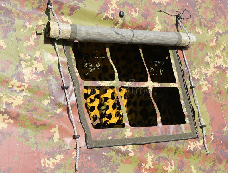 Small window detail of a military tent with camouflage fabric set up in a training camp during war stock images
