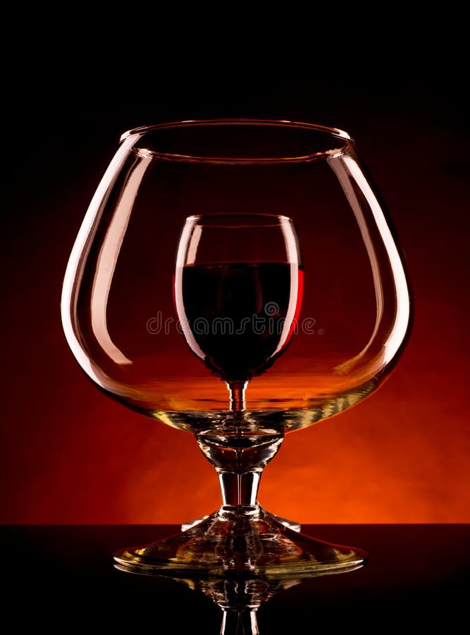 Small wineglass is visible through a large glass of wine