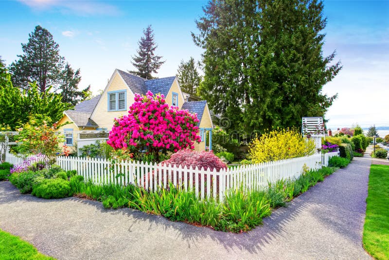 Small Yellow house exterior with White picket fence and Decorative Gate. Northwest,USA