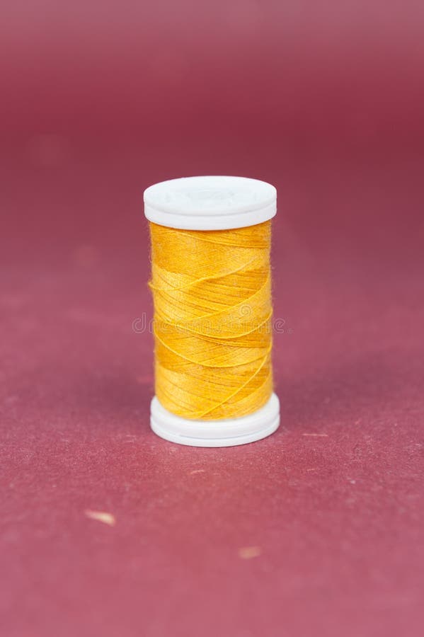 Small Yellow Sewing Thread on Red Background Stock Image Image of