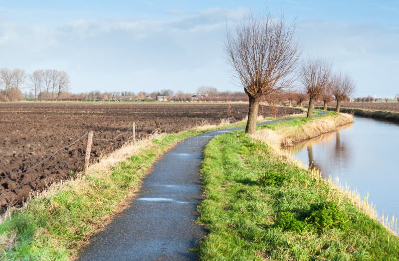 Smalle fietsweg naast een het kronkelen rivier. stock afbeelding Smalle fietsweg naast een het kronkelen rivier. stock afbeelding