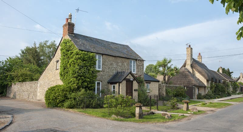 Smalle steeg met romantische met stro bedekte huizen en steenplattelandshuisjes in het mooie dorp van Munsterlovell, Cotswolds, O stock afbeelding Smalle steeg met romantische met stro bedekte huizen en steenplattelandshuisjes in het mooie dorp van Munsterlovell, Cotswolds, O stock afbeelding